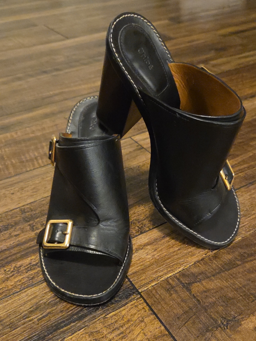 Chloé black leather double-buckle block heel mules featuring gold-tone hardware